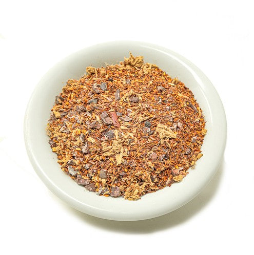 White bowl filled with a mix of dried herbs and spices on a white background