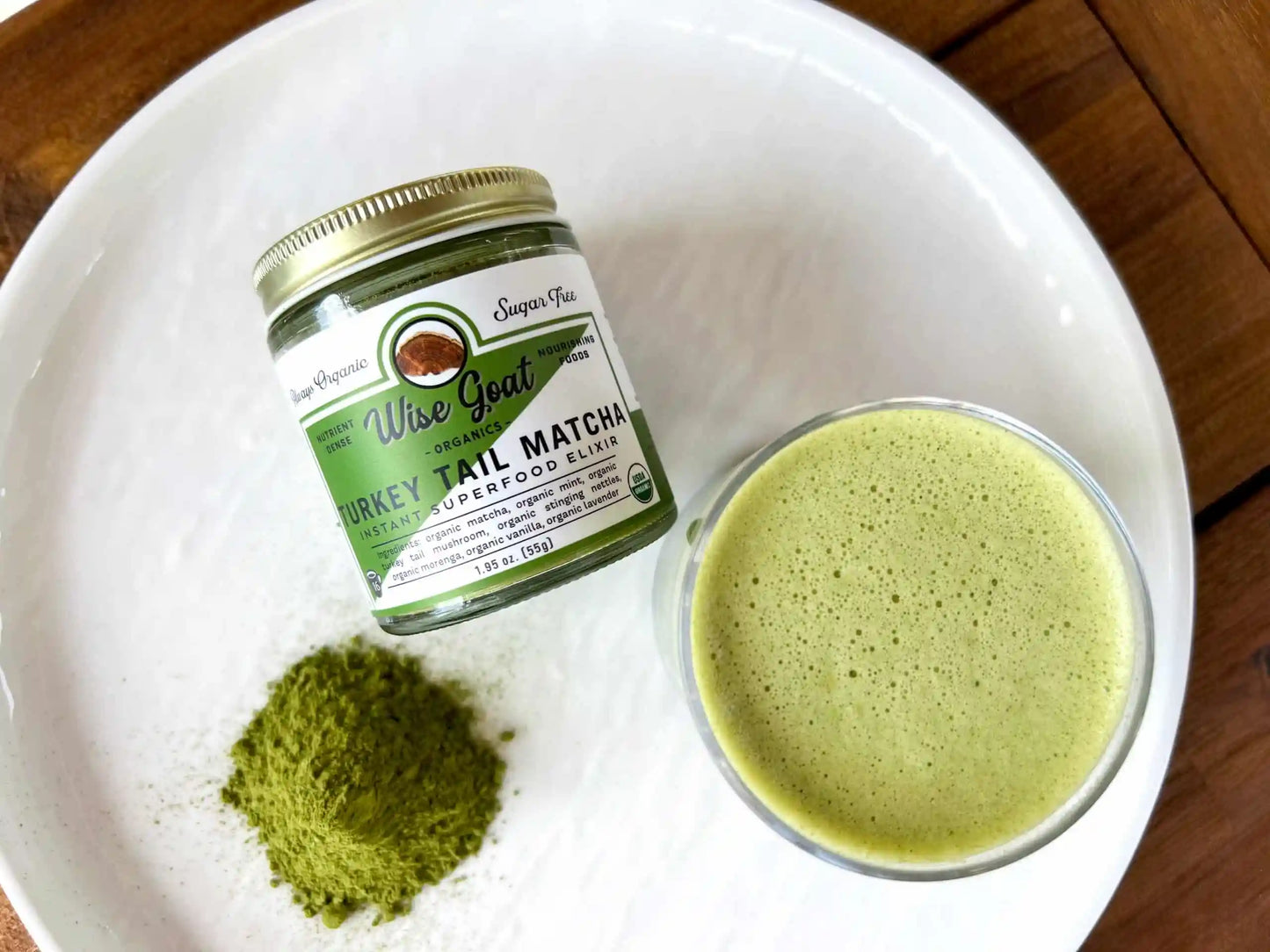 Wise Tea matcha powder jar with a bowl of matcha green tea on a white plate.