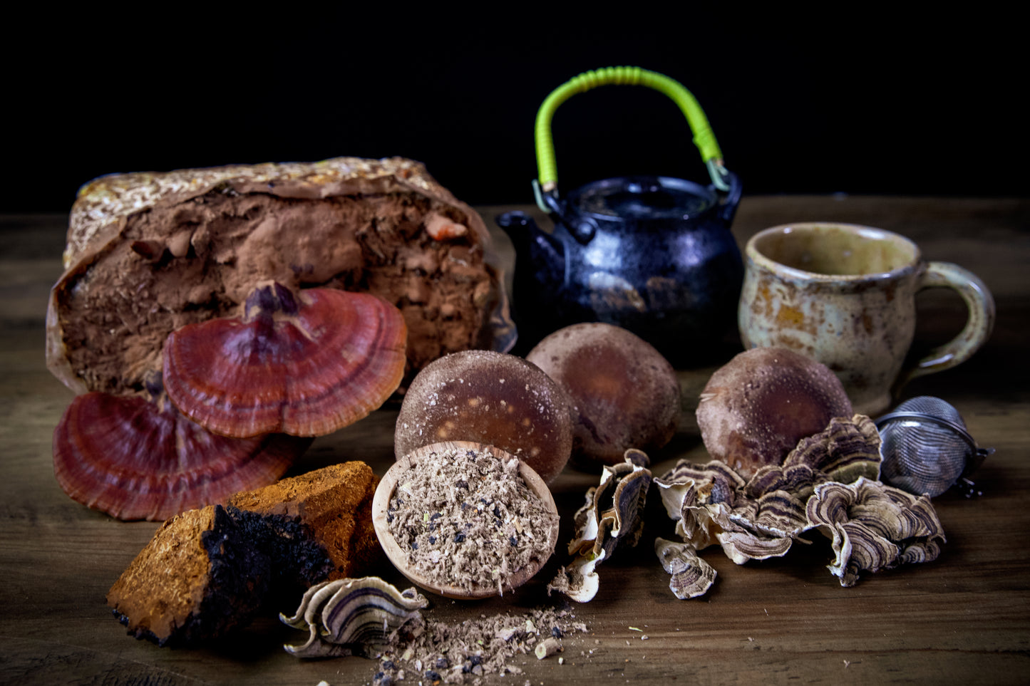 Mushroom products and a teapot on a wooden surface with a dark background
