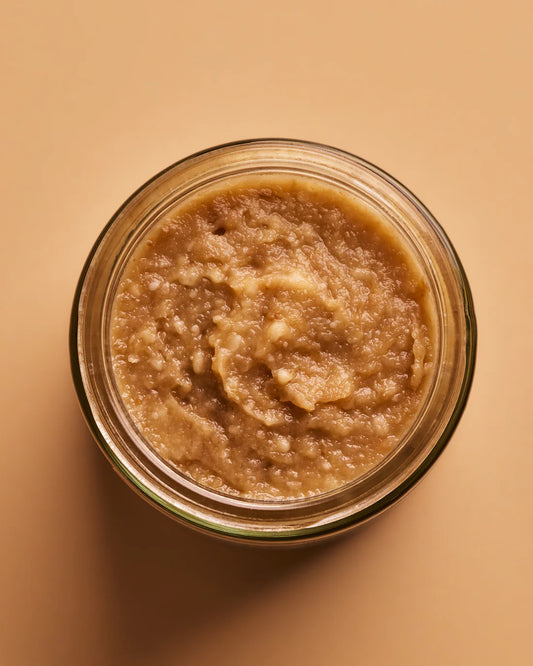 Jar of applesauce on a beige background