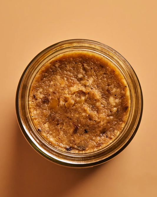 Jar of brown spreadable food on a beige background