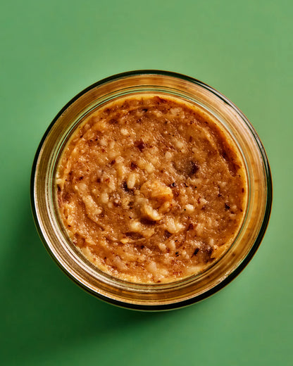 Jar of peanut butter on a green background