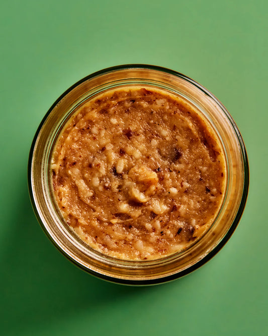Jar of peanut butter on a green background